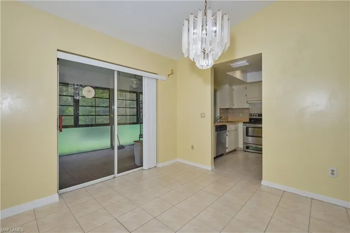 Spare room with a notable chandelier, sink, and light tile floors