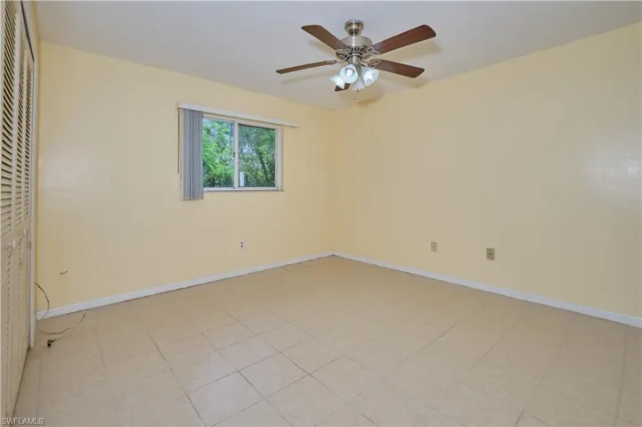 Spare room with ceiling fan and light tile floors