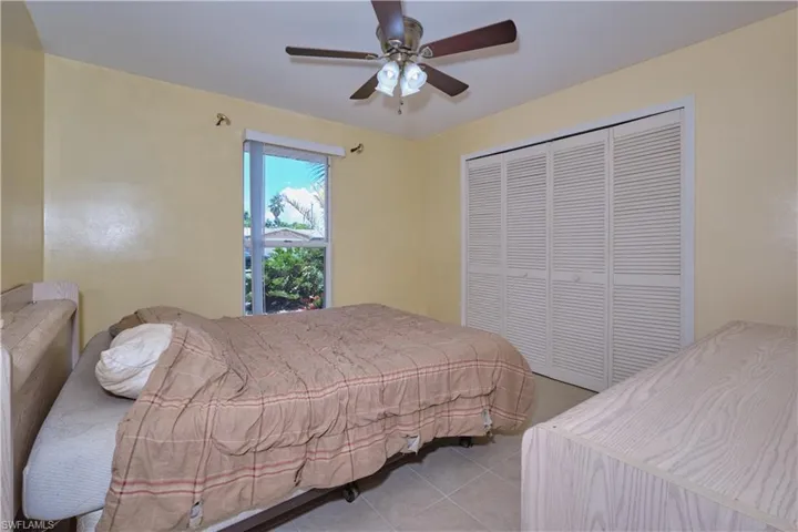 Tiled bedroom featuring a closet and ceiling fan