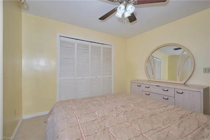 Bedroom with a closet, carpet, and ceiling fan