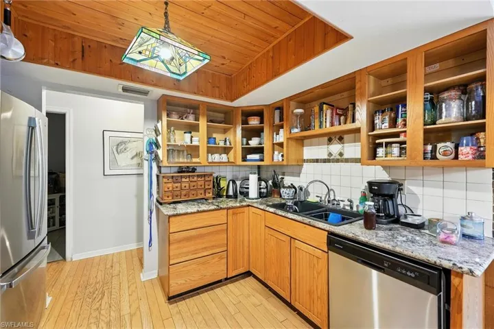Kitchen with appliances with stainless steel finishes, wood ceiling, open shelves, light wood finished floors, and tasteful backsplash