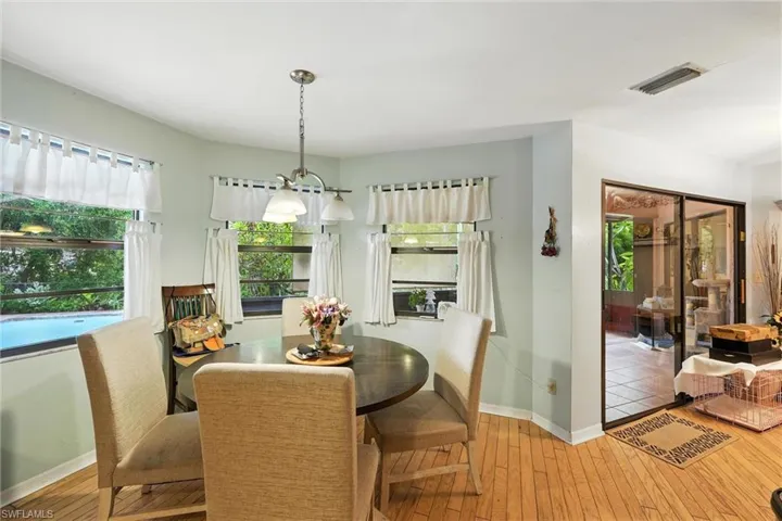 Dining room with wood-type flooring and a chandelier