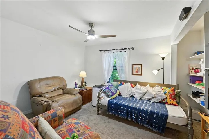Living area featuring a ceiling fan and carpet floors