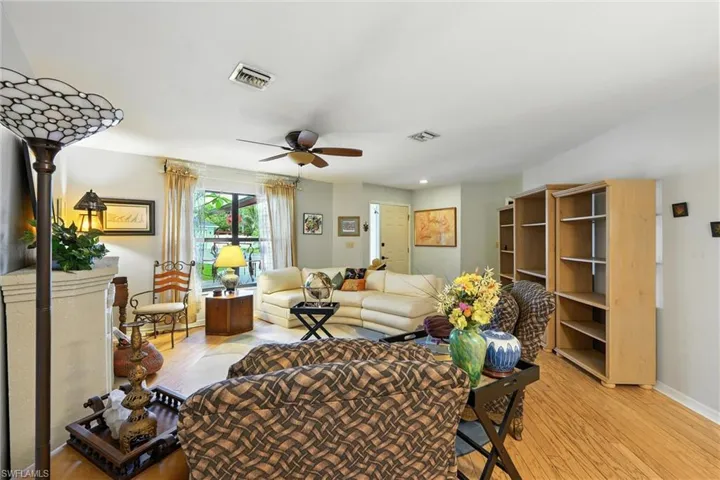 Living room with light wood-style floors, ceiling fan, and recessed lighting