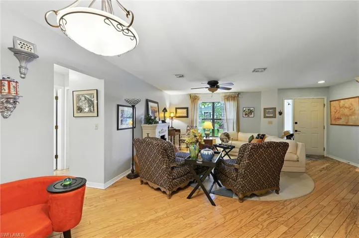 Living room featuring light wood finished floors, a ceiling fan, and recessed lighting