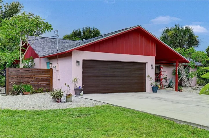 View of front facade featuring a garage, concrete driveway, stucco siding, and roof with shingles