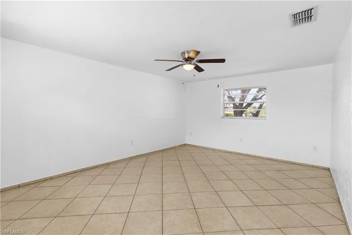 Spare room with visible vents and ceiling fan