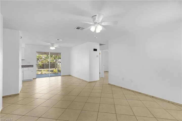 Empty room featuring a ceiling fan, baseboards, light tile patterned floors, and visible vents