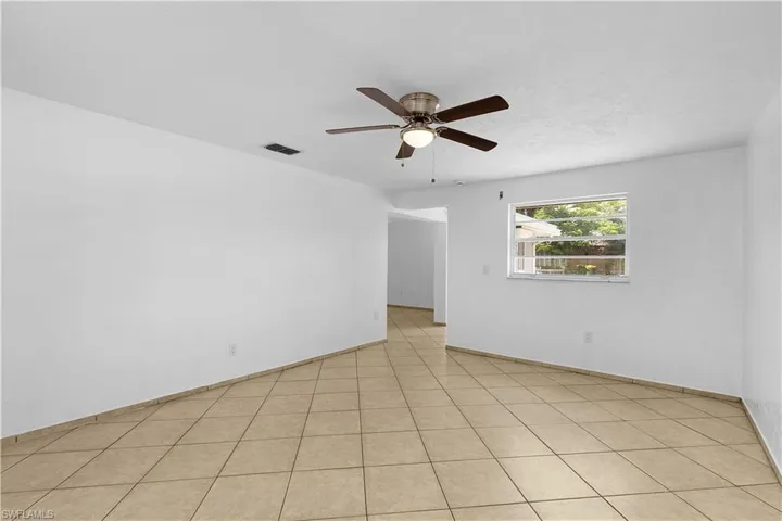 Empty room featuring visible vents and a ceiling fan