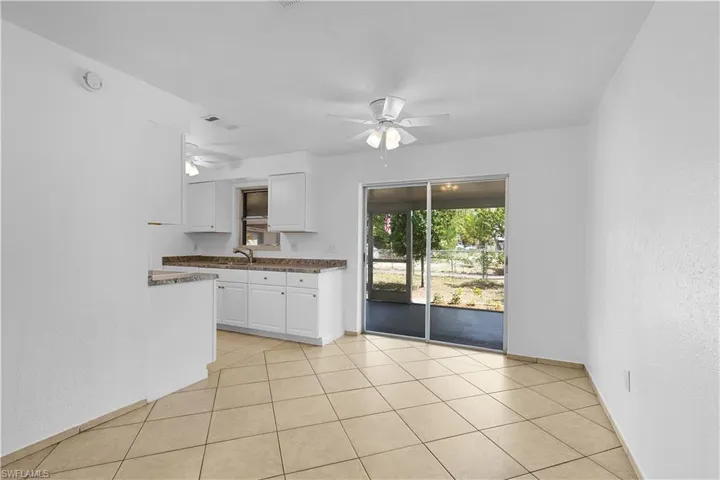Kitchen featuring a ceiling fan, baseboards, white cabinets, and visible vents