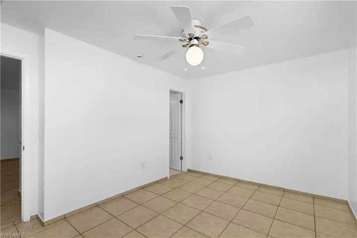 Unfurnished room featuring light tile patterned floors and ceiling fan