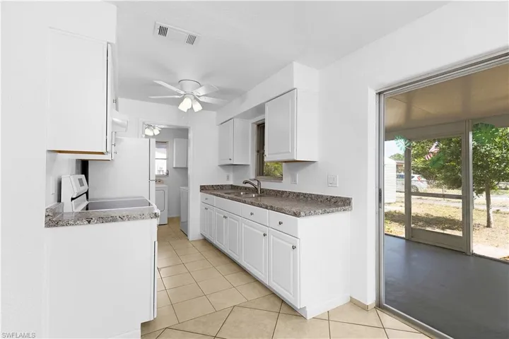 Kitchen featuring ceiling fan, light tile patterned floors, visible vents, and white cabinets