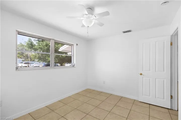 Empty room featuring a ceiling fan, baseboards, light tile patterned floors, and visible vents