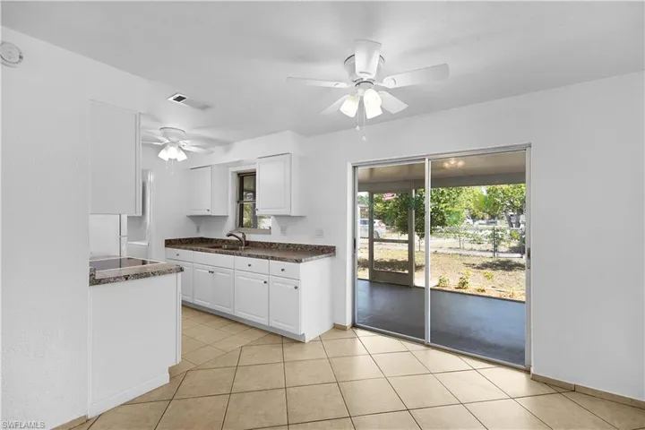 Kitchen featuring a sink, ceiling fan, plenty of natural light, and white cabinets