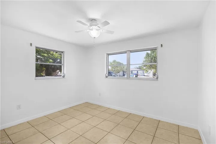 Spare room featuring ceiling fan and baseboards
