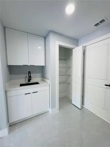 Bar with sink and white cabinets