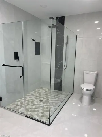 Bathroom featuring toilet and an enclosed shower