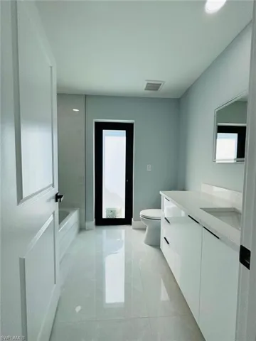 Bathroom featuring tile patterned flooring, vanity, and toilet