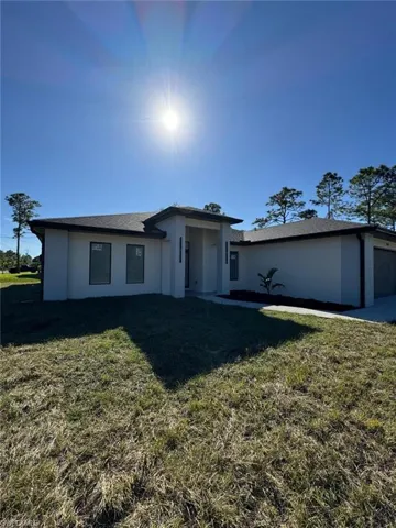 View of front of property featuring a front yard and a garage