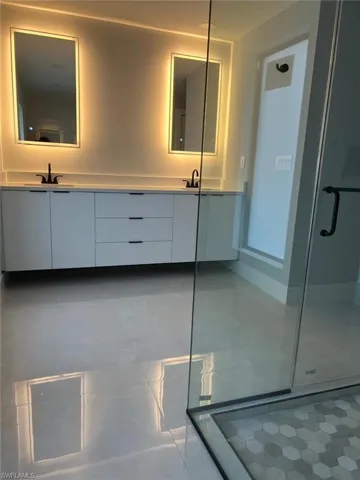 Bathroom featuring vanity and a shower with door