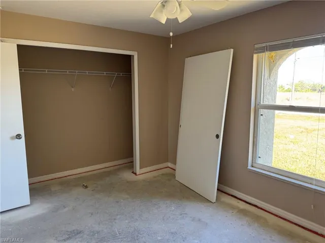 Unfurnished room with ceiling fan with notable chandelier and lofted ceiling