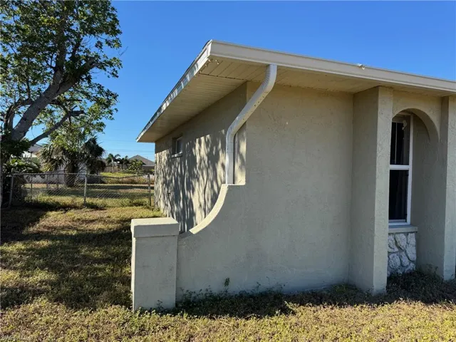 View of property exterior featuring ceiling fan and a yard