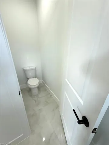 Bathroom featuring baseboards and toilet
