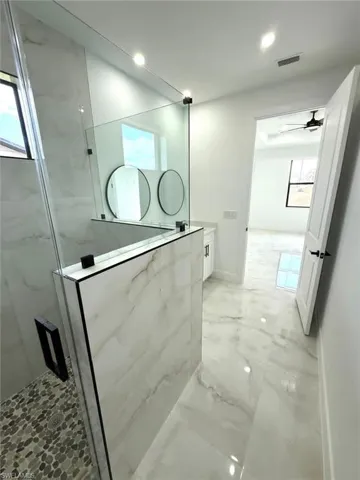 Full bathroom with a marble finish shower, ceiling fan, and recessed lighting