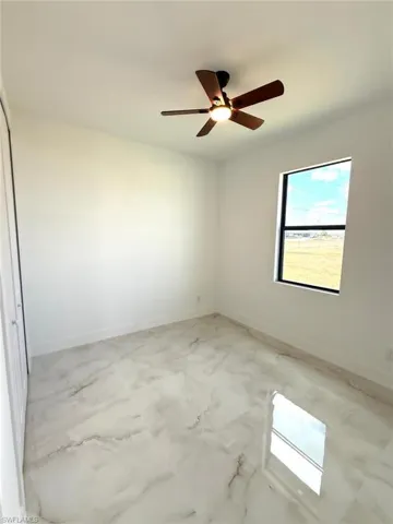 Unfurnished room with baseboards and ceiling fan
