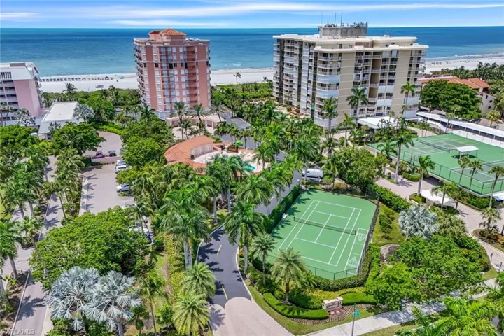 Birds eye view of property with a water view and a beach view
