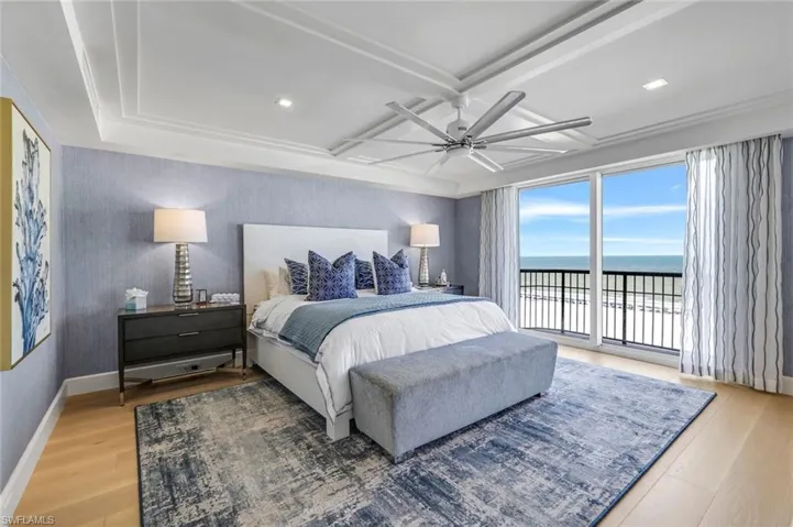 Bedroom featuring ceiling fan, access to exterior, a water view, and hardwood / wood-style flooring