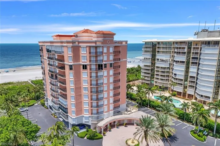 View of building exterior with a water view and a community pool
