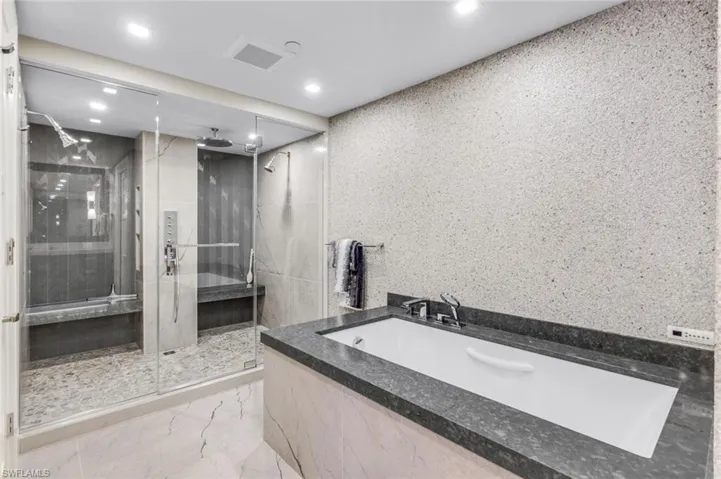 Bathroom featuring tile walls, plus walk in shower, and tile patterned flooring