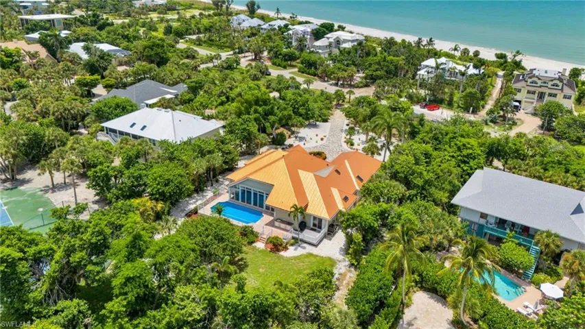 Property featuring a terra cotta tile roof, large swimming pool, and extensive surrounding greenery