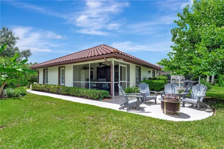 Rear view of property with ceiling fan, a lawn, a patio, and an outdoor fire pit