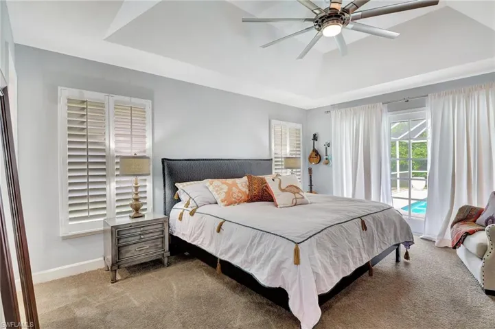 Bedroom with access to exterior, ceiling fan, and carpet floors