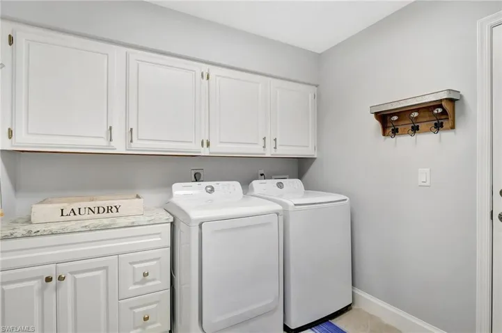Laundry room with cabinets and washer and clothes dryer
