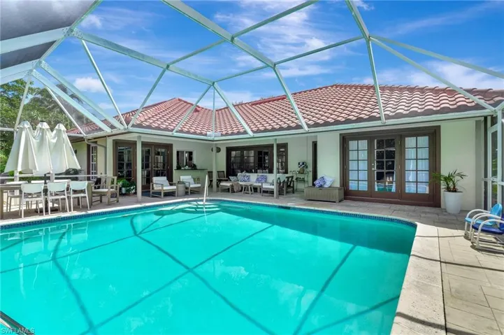 View of pool featuring an outdoor hangout area, glass enclosure, a patio area, and french doors