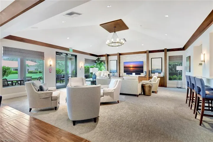 Living room featuring vaulted ceiling, plenty of natural light, light hardwood / wood-style flooring, and a chandelier
