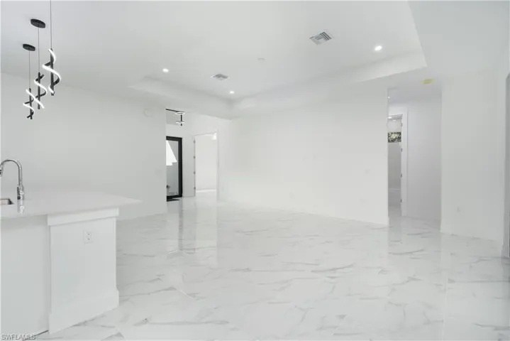 Unfurnished room featuring a tray ceiling and recessed lighting