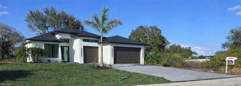 View of front facade featuring a 3+ garage, a front lawn, stucco siding, decorative driveway, and a Hurricane shingled roof
