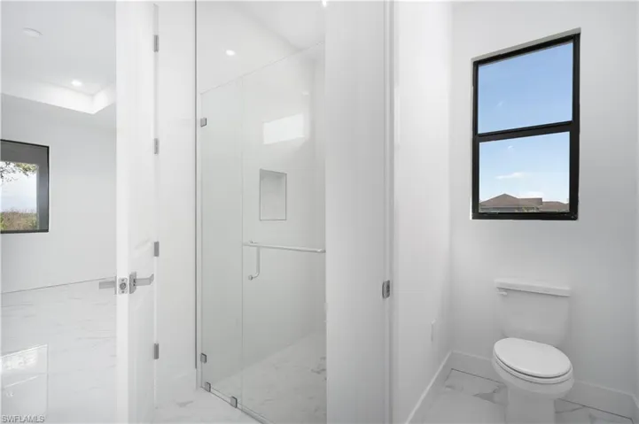 Full bathroom with a shower stall and light marble finish flooring