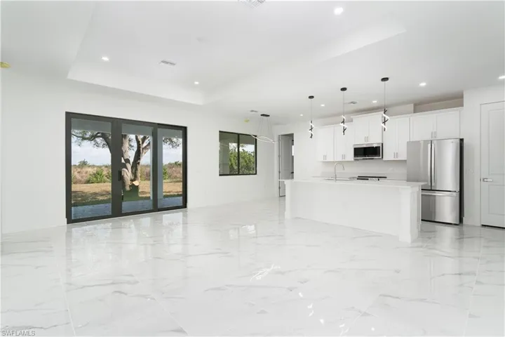 Unfurnished living room featuring a tray ceiling and recessed lighting