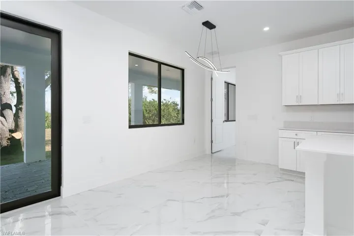 Unfurnished dining area with recessed lighting and light marble finish flooring