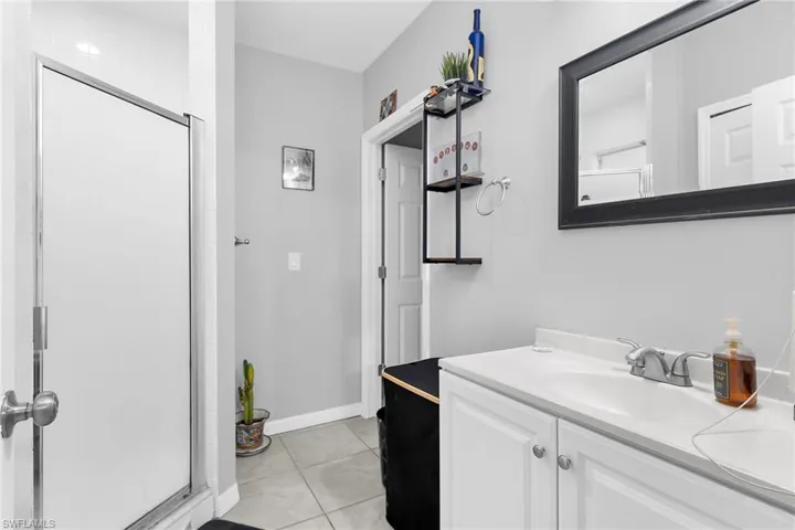 Bathroom featuring vanity, a stall shower, and light tile patterned floors
