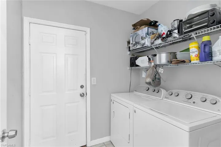 Laundry room featuring washing machine and dryer and baseboards