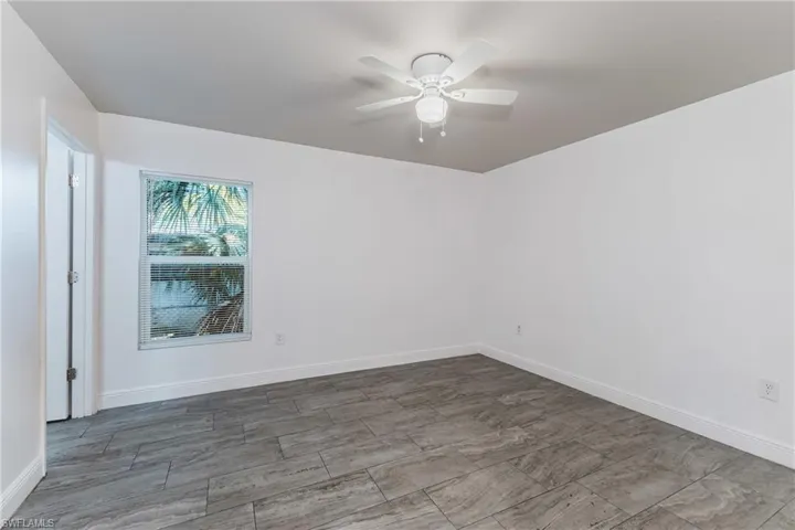 Unfurnished room featuring a ceiling fan and wood finish floors