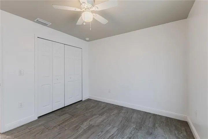 Unfurnished bedroom with wood finished floors, a closet, and ceiling fan