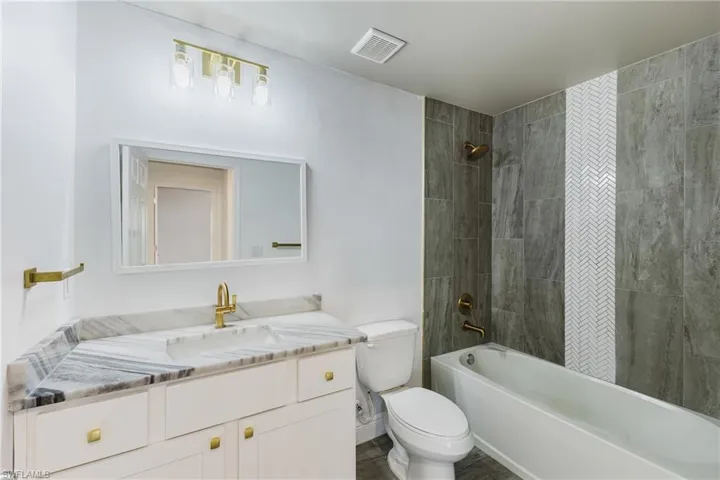 Bathroom featuring shower / bathtub combination with curtain and vanity