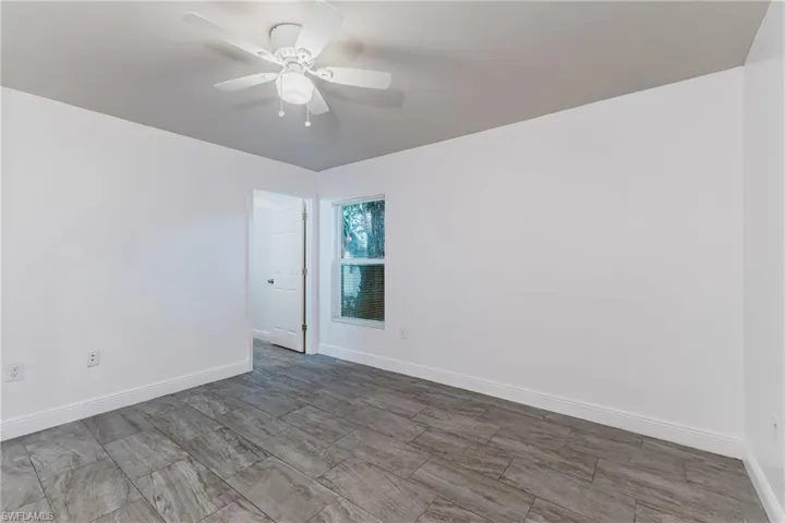 Empty room with ceiling fan and wood tiled floors